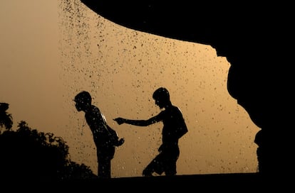 Un grupo de niños se refresca en una fuente en Nueva Delhi, donde las temperaturas han alcanzado los 40 grados centígrados.