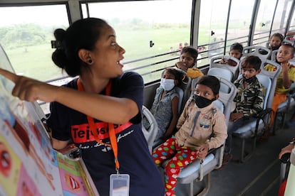 Una profesora enseña a un grupo de estudiantes dentro de un autobús en Nueva Delhi, India, el 9 de agosto de 2021.