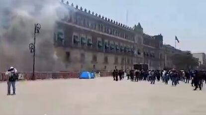 Un grupo de normalistas arroja artefactos explosivos contra la fachada del Palacio Nacional, en Ciudad de México, el 13 de mayo de 2024.