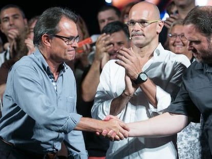 Artur Mas y Oriol Junqueras se dan la mano, en el centro, Raul Romeva.