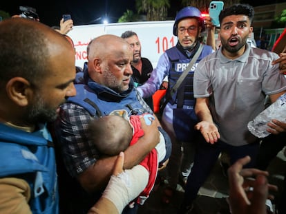 Al Jazeera's correspondent in Gaza, Wael Dahdouh, holds in his arms the body of one of his sons, killed with his wife and daughter in an Israeli bombing, at the al-Aqsa hospital in the south of the Strip, on October 25, 2023.