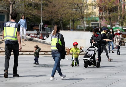 Policías patrullan entre niños y niñas en las calles de Madrid este lunes, el segundo día que pueden salir desde que se decretó el estado de alarma por la pandemia de coronavirus.