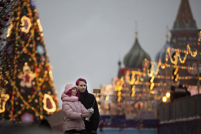 Una pareja se hace un selfie en un árbol de navidad, con la Catedral de San Basilio al fondo, en la Plaza Roja de Moscú (Rusia), el 4 de diciembre de 2018.