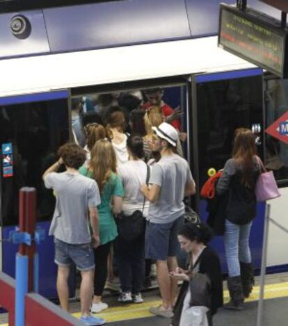 Numerosas personas intentan acceder al interior del metro en la estación de Príncipe Pío durante los paros parciales.