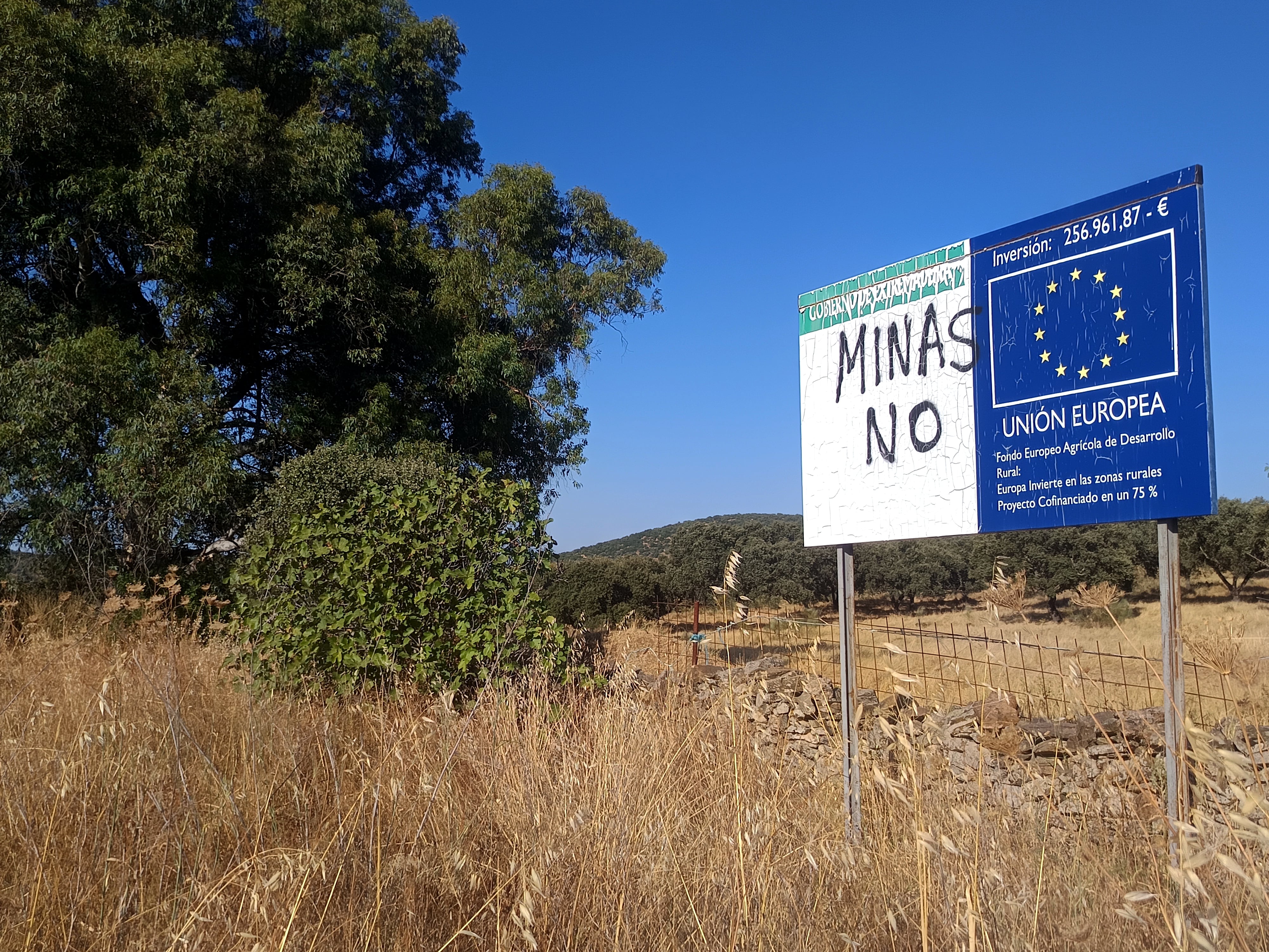 Pintada contra las minas en un cartel de inversiones europeas para el desarrollo rural, en Alconchel (Badajoz).