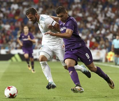 El delantero argentino de la Fiorentina Giovanni Simeone (d) lucha el balón con Nacho, defensa del Real Madrid.