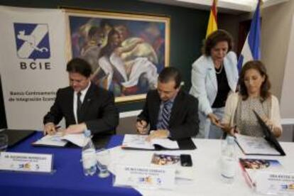 El ministro hondureño de Finanzas, Wilfredo Cerrato (C), el vicepresidente del Banco Centroamericano de Integración Económica (BCIE), Alejandro Rodríguez (i), y la agregada comercial de España en Tegucigalpa, Reyes Sallent (d), durante un acto en Tegucigalpa (Honduras), donde se lleva a cabo la firma de un proyecto para crear la Red Nacional de Centros Multimedia para el Desarrollo Socioeconómico de Honduras.