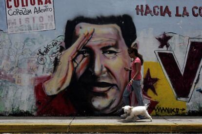 Una mujer pasa frente a un mural pintado con la imagen de Hugo Chávez, en una calle de Caracas, en una imagen de 2010.