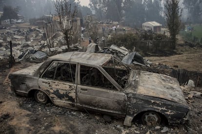 En la imagen, un coche carbonizado entre los escombros que ha dejado el incendio forestal en Santa Olga.