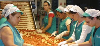 Mujeres trabajando en una cadena de producción.