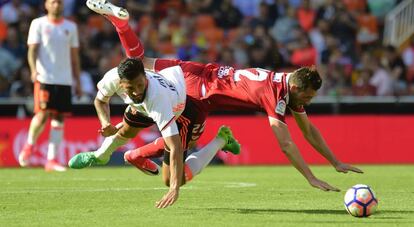 Franco V&aacute;zquez, del Sevilla, choca con Garay, del Valencia.