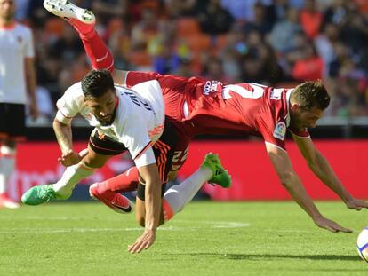 Franco V&aacute;zquez, del Sevilla, choca con Garay, del Valencia.