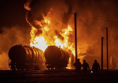 Los residentes observan cómo se incendian vagones cisterna tras los recientes bombardeos en un cruce ferroviario en Donetsk el martes.