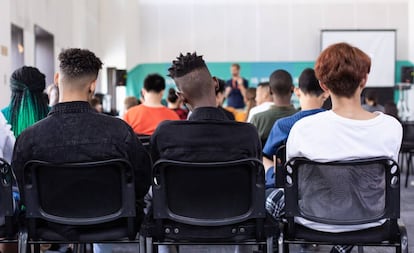 Un grupo de alumnos atienden a las explicaciones de un profesor.