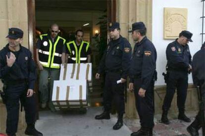 Dos policías sacan cajas con documentación de la sede del Ayuntamiento de Marbella.