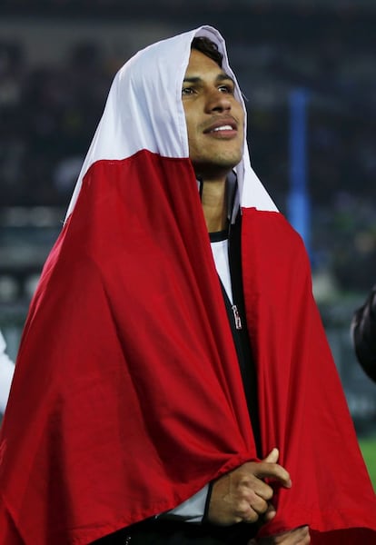 Paolo Guerrero con la bandera de Perú celebra la victoria de su equipo.