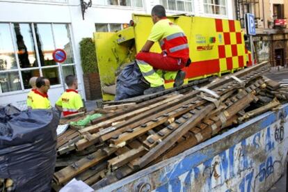 Operarios del Selur transportan parte del material retirado de la Puerta del Sol tras el intento de instalación de un punto informativo del 15-M en la plaza.