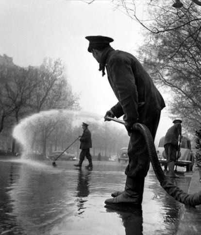 Un operario regando el Paseo de Recoletos de Madrid en 1953 (arriba).