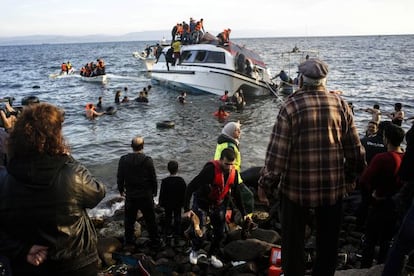 Residentes de la isla griega de Lesbos ayudan a unos refugiados a desembarcar. 