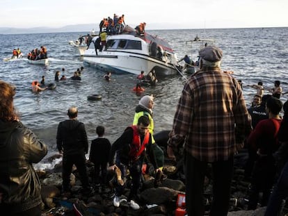 Moradores da ilha grega de Lesbos ajudam refugiados a desembarcar.