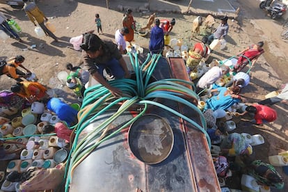 Moradores de bairros margeados indianos recolhem água potável de uma cisterna municipal na zona de Durga Nagar, em Bhopal, em 21 de março.