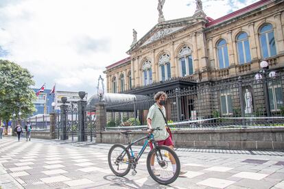 Un hombre con su bicicleta frente al Teatro Nacional de San José, Costa Rica.