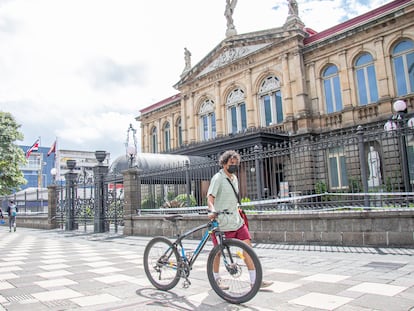 Un hombre con su bicicleta frente al Teatro Nacional de San José, Costa Rica.