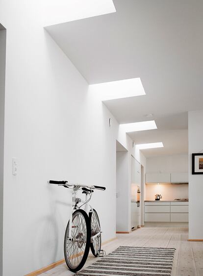 Una ventana de techo para cubierta plana ilumina este pasillo interior. De Velux