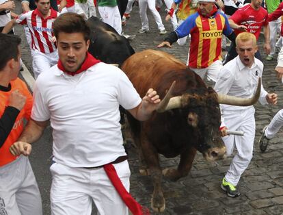 Varios mozos corren delante de los toros de la ganadería de Victoriano del Río, de Guadalix de la Sierra (Madrid), durante la tercera carrera de los Sanfermines, en el tramo de Telefónica.