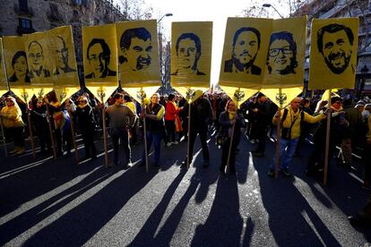 Manifestantes carregam cartazes com as fotos dos presos políticos acusados de traição.