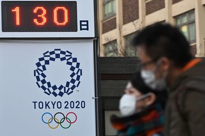 Ciudadanos de Yokohama pasan ante un cartel recordando que faltan 130 días para Tokio 2020.