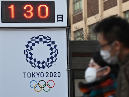 Ciudadanos de Yokohama pasan ante un cartel recordando que faltan 130 días para Tokio 2020.