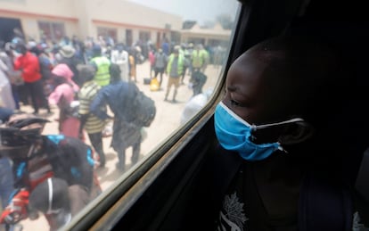 Un niño con mascarilla mira por la ventana de un autobús en Dakar, Senegal.