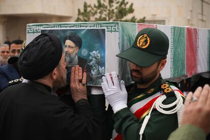 Una foto proporcionada por la Oficina Presidencial Iraní muestra a un clérigo besando el ataúd de Ebrahim Raisí.