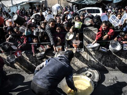 Decenas de palestinos tratan de recibir comida este jueves por parte de una ONG en Rafah, en el sur de Gaza.