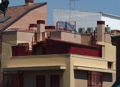 Una azotea con una terraza cerrada con una carpintería de aluminio, placas solares y aparatos de aire acondicionado.