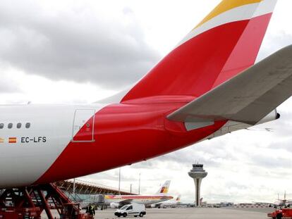 Un avi&oacute;n con la nueva imagen de Iberia en la T4 de Barajas. Al fondo se apreia un aparato con el antiguo logotipo./ P. Monge