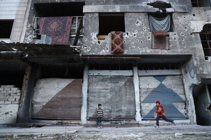 Varios niños sirios juegan junto a un edificio destruido en la ciudad rebelde de Duma (Siria).