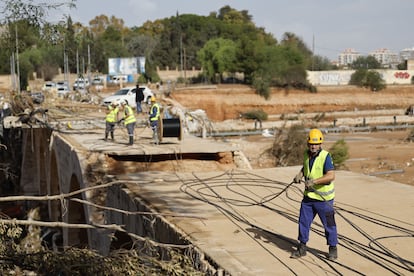 Operarios trabajan para restablecer las comunicaciones en el municipio valenciano de Torrent, este jueves. 