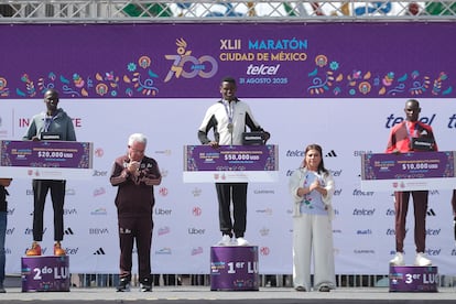 El etíope Tadu Abate Deme (c) ganador del primer lugar, junto a los kenianos Bernard Kipkorir (i) segundo lugar y Edwin Kiprop Kiptoo (d) tercer lugar de la categoría élite varonil, durante la premiación con la jefa de Gobierno, Clara Brugada.