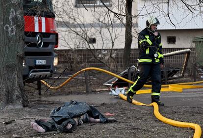 Un bombero pasa junto a una víctima de un ataque ruso en una zona residencial de la capital ucrania, este martes. Mientras arrecian los ataques rusos contra zonas residenciales en Kiev, tres jefes de Gobierno de países de la UE ―Polonia, República Checa y Eslovenia― se dirigen en tren a la capital ucrania, en la primera visita a la ciudad de dirigentes internacionales desde el inicio de la ofensiva rusa hace casi tres semanas. Varsovia ha puesto en marcha la iniciativa a pesar de no contar con el respaldo de la UE y de que el presidente del Consejo Europeo, Charles Michel, advirtió de los riesgos de seguridad que implicaba el viaje, según indican fuentes comunitarias en Bruselas.