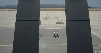 Dos trabajadores en la pista del aeropuerto de Castellón.