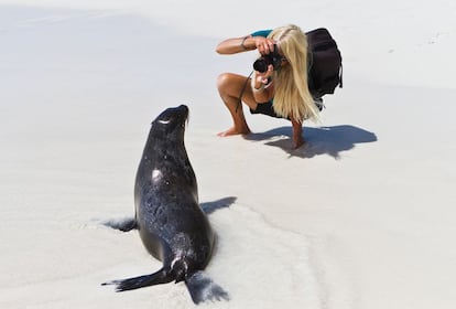 Una turista retrata a un león marino en una playa de la isla de Santiago, en Galápagos (Ecuador).