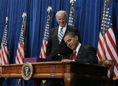 Barack Obama firma, en presencia del vicepresidente Joe Biden, el plan de estímulo económico.