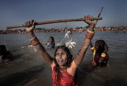Varias mujeres que creen estar poseídas por espíritus malignos se toman baños sagrados mientras cantan mantras y danzan un día de luna llena durante la celebración del Festival de los fantasmas, en las orillas del río Kamala en el distrito de Danusha (Nepal).