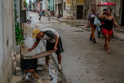 Un hombre prepara la comida en la calle debido al apagón, el día 19 de octubre. 