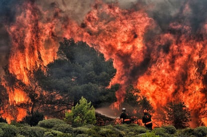 O problema da mudança climática - para muitos especialistas, o grande desafio da humanidade para este século - atravessa todo o relatório da ONU. Na imagem, bombeiros tentam apagar um incêndio na aldeia grega de Kineta, em 24 de julho de 2018.