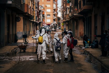 Unos voluntarios trabajan en labores de limpieza en una calle de Alfafar, Valencia