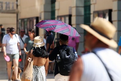 Viandantes soportan las altas temperaturas por las calles de Málaga el 12 de agosto de 2025.