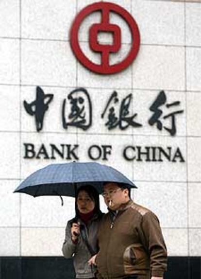 Una pareja pasea junto al Banco de China en Shangai.